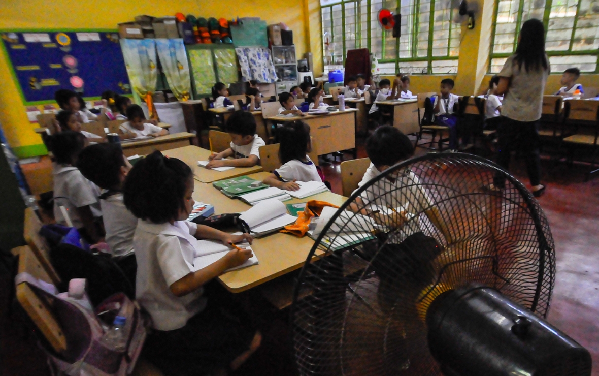 Students from Justo Lukban Elementary School rely on electric fans to keep themselves cool inside their warming classrooms. Metro Manila and other parts of the country are currently dealing with temperatures beyond 40 degrees. Photo by NORMAN ARAGA